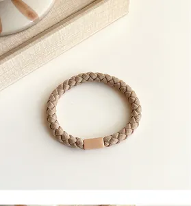 Detail of woven high-elastic hair tie in milk coffee beige with minimalist connector