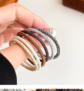Vue détaillée de six élastiques à cheveux brillants montrant textures et motifs tissés
