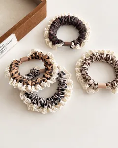 Close-up showing four leopard print hair scrunchies with elegant lace trim and soft texture