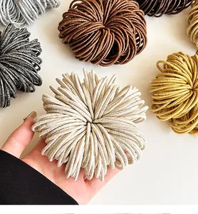 Détail d'élastiques à cheveux brillants multicolores montrant la texture et l'élasticité