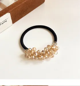 Detail of champagne crystal beads on a high elasticity black ponytail hair tie