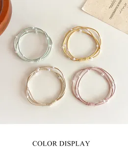 Detail van meerlaagse elastische haarelastiekjes met parels in vier frisse kleuren