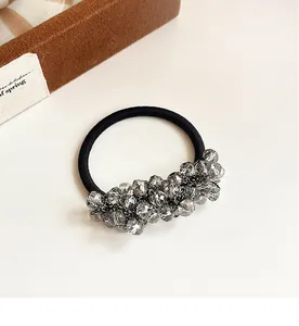 Macro shot of high-elasticity hair tie with grey faceted crystal beads and premium texture