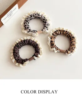 Detail of three leopard print hair scrunchies with elegant lace trim and soft fabric
