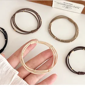 Gros plan d'élastiques à cheveux multi-brins avec perles dorées aux tons café