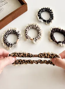 Close-up of leopard print scrunchies with lace trim showing high elasticity and texture