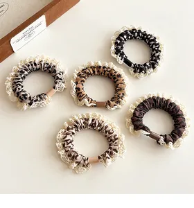 Detailed view of leopard print hair ties with lace trim in a 5-piece stylish set