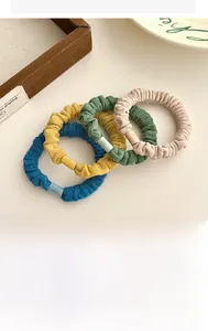 Vue détaillée de quatre chouchous en velours colorés avec boucles en résine décoratives