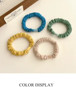 Détail de chouchous élastiques en velours en couleurs bleu, vert, jaune et abricot