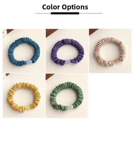 Détail de cinq chouchous en tricot de couleur avec texture élastique et petits blocs décoratifs