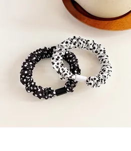 Dettaglio ravvicinato di elastici per capelli a pois in nero e bianco classici
