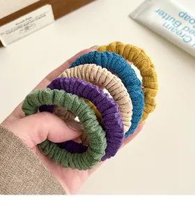 Détail de cinq chouchous élastiques colorés en tissu tricoté avec texture côtelée