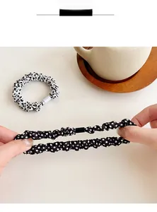 Dettaglio dell'elastico per capelli a pois teso per mostrare la sua resistenza