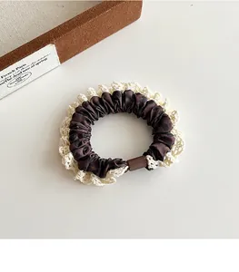 Detailed close-up of leopard print hair scrunchie with crochet lace trim and brown buckle