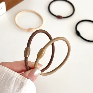 Elastische gevlochten haarelastiekjes in aardetinten met glanzende ovale gespen