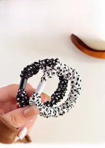 Dettaglio degli elastici per capelli a pois bianchi e neri con tessuto plissettato