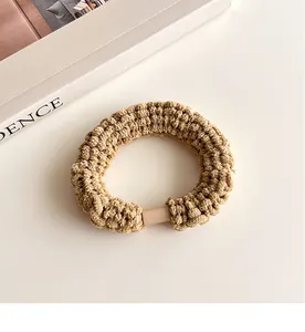 Macro d'un élastique à cheveux en tricot kaki avec texture et fermoir carré rose clair