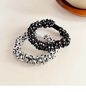 Dettaglio di elastici per capelli a pois con trama in tessuto plissettato ed elastico