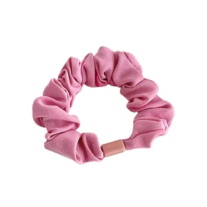 Pink fabric scrunchie with subtle twill texture and matching resin buckle closure