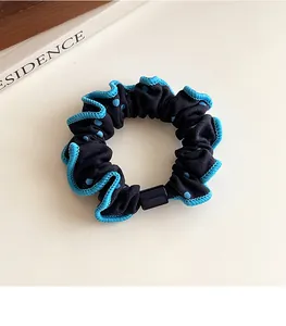 Detalle de coletero azul marino con lunares y bordes de encaje ondulado azul claro