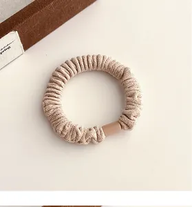 Détail du chouchou en velours beige montrant une grande élasticité et une texture côtelée
