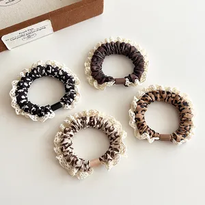 Set of 4 leopard print hair scrunchies with white lace trim and elastic hair ties