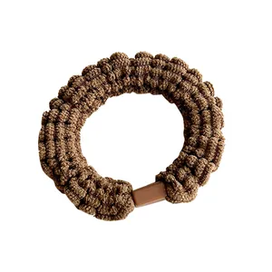 Chouchou en tricot marron avec tissu texturé et fermoir décoratif en plastique assorti