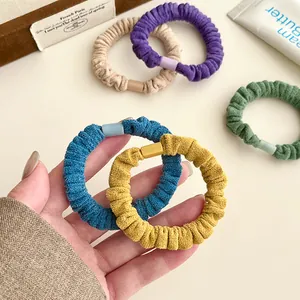 Cinq chouchous en velours aux couleurs pastel avec texture de tissu côtelé minimaliste
