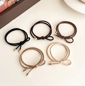Detail of high-elasticity hair ties with dual-strand design and metallic gold cylinder tips
