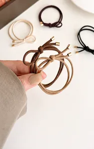 Detail of high-elastic double-layered bow hair tie with gold metal cylinder caps