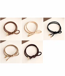 Detail of high-elasticity bow hair ties with gold metallic ends in five earth-toned colors
