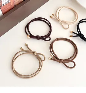 Close-up of elastic bow hair ties with metal ends in neutral beige and brown tones