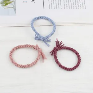 Three braided twist hair ties in light blue, pink, and purple with knotted tassel detail