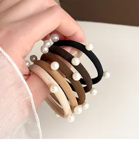 Dettaglio di elastici per capelli ad alta elasticità con perle in varie tonalità caffè