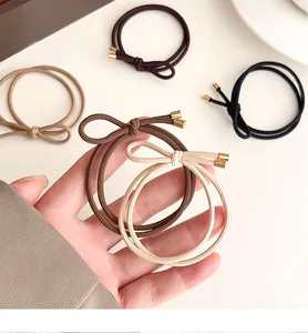 Close-up of double-strand elastic bow hair ties with elegant gold metal cylinders