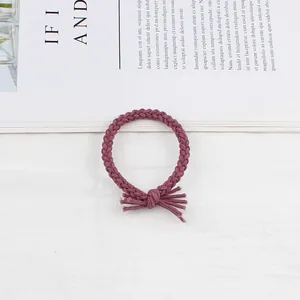 Detailed view of hand-braided dark purple elastic hair tie with stylish tassel knot design