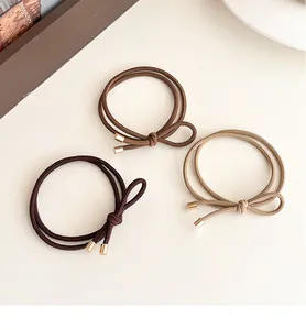 Macro shot of high-elastic bow hair ties in three neutral earth-tone colors
