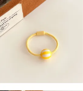 Detalle de coletero elástico amarillo con cuenta rayada y clip rectangular duradero