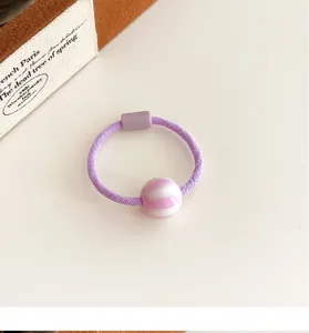 Detalle de goma de pelo violeta con cuenta de rayas rosas y unión de plástico duradera