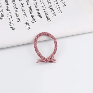 Close-up of pink braided hair elastic with minimalist knot design on white background