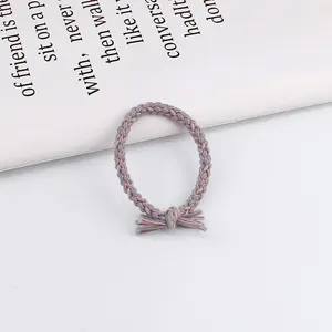 Detail of twisted grey and pink braided hair tie with a decorative tassel knot