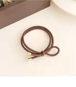 Close-up of durable brown elastic hair tie featuring golden cylindrical metal ends