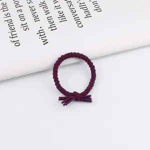 Braided red and blue twist hair tie with knot detail on minimalist white background