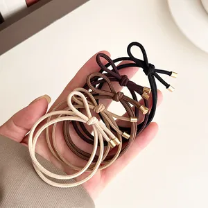 Set of four high-elastic bow hair ties in neutral earth tones with gold metal ends