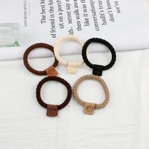 Set mit 5 geflochtenen elastischen Haargummis und Smiley-Lederlabels in neutralen Tönen