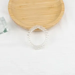 Dettaglio dell'elastico per capelli a spirale trasparente ad alta elasticità su tessuto