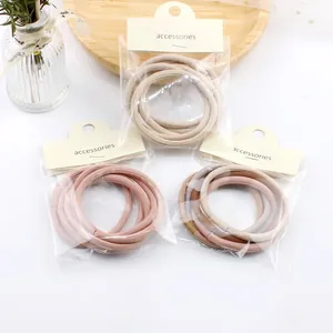Detailed view of elastic hair ties in beige and coffee tones with card packaging
