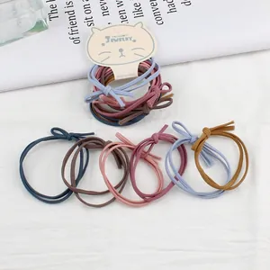 Detail van snoepkleurige elastische haarelastiekjes in Morandi-tinten op modekaart
