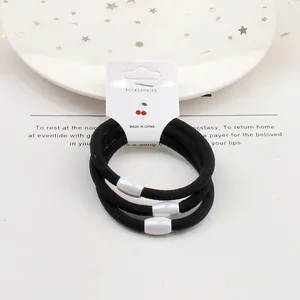 Set of 3 high-elastic black hair ties with iridescent resin beads on a paper card