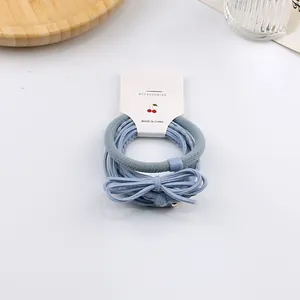 Vista dettagliata del set di elastici blu per capelli con fiocco su sfondo bianco pulito